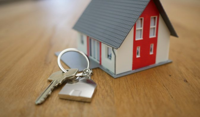 white and red wooden house miniature on brown table